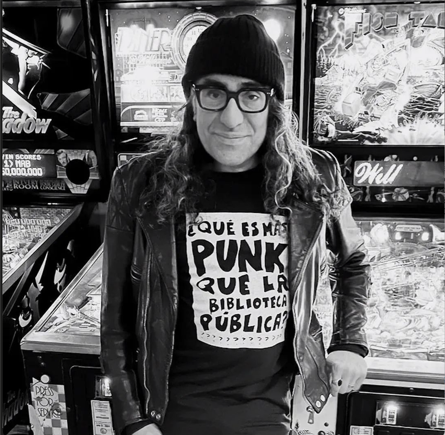 Professor Mauricio Cordero standing in front of arcade games tables